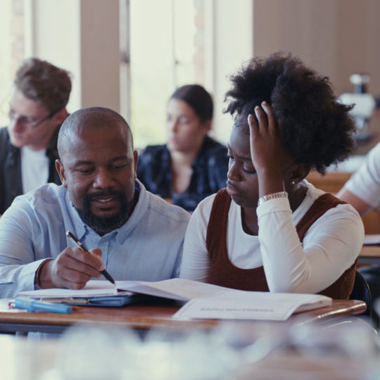 Shot of a teacher assisting a struggling student with schoolwork in a classroom